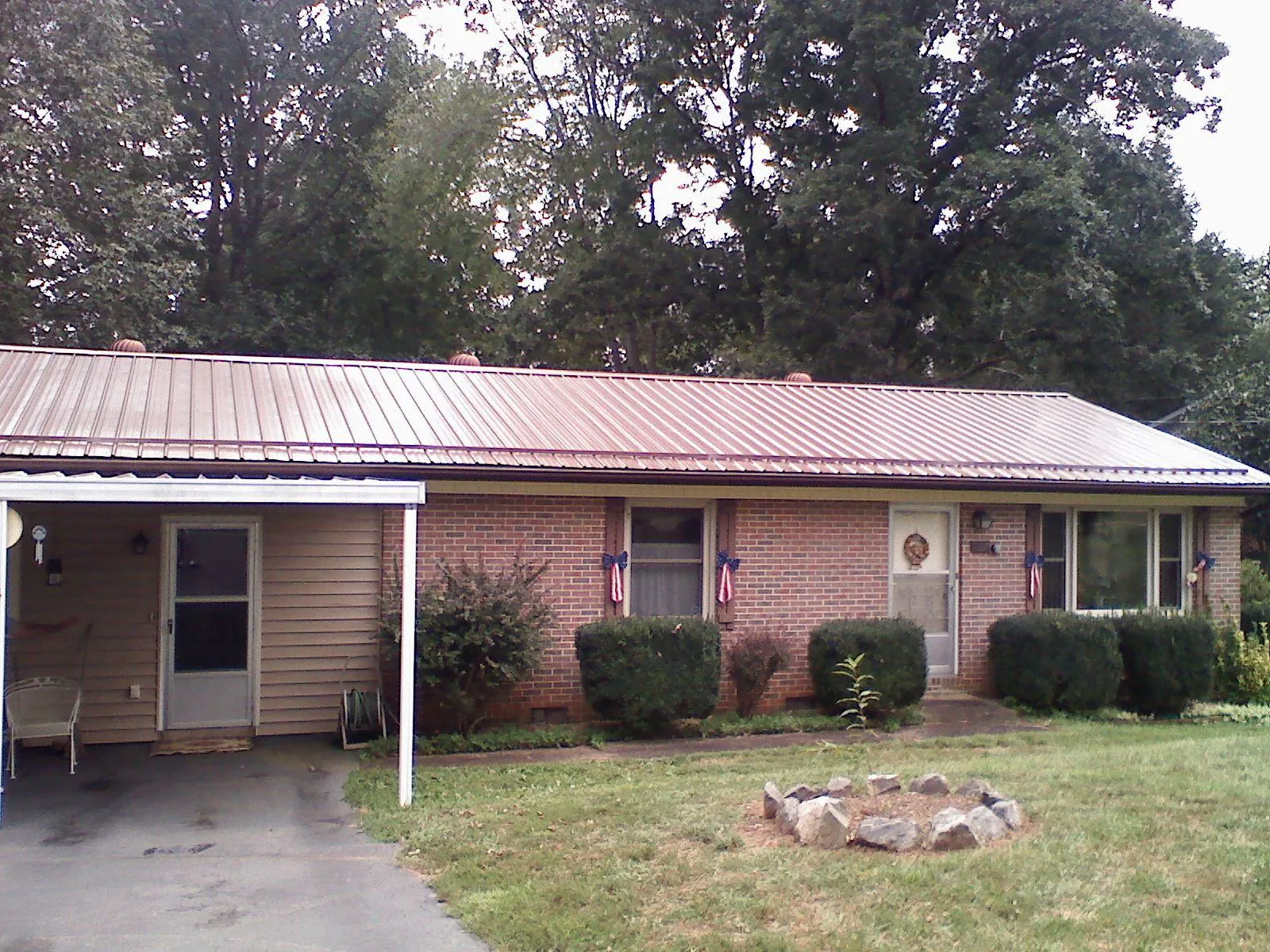 Bronze metal roof and carport on a brick ranch home — Roof Repair work by our crew in Homeland