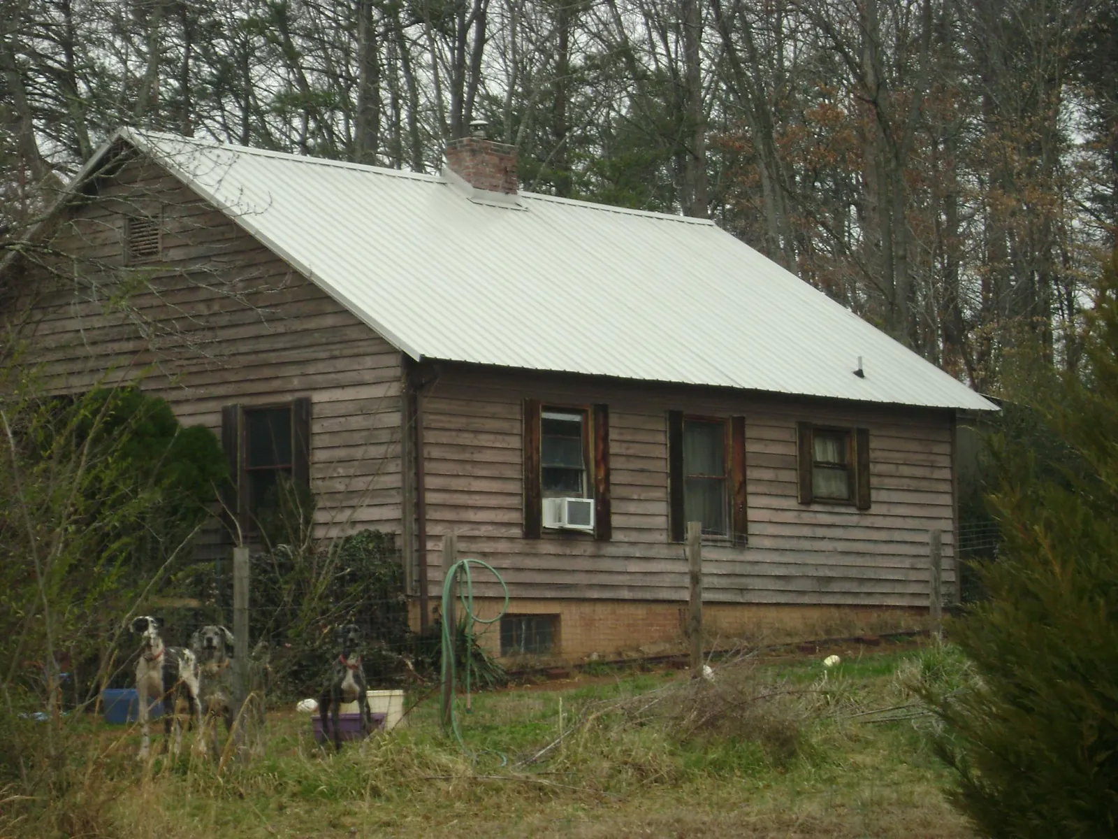 White metal roof on an old wood sided farmhouse, from a Metal Roof Installation job in Homeland